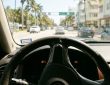 Driver experiencing steering wheel stiffness in a car under Miami heat conditions