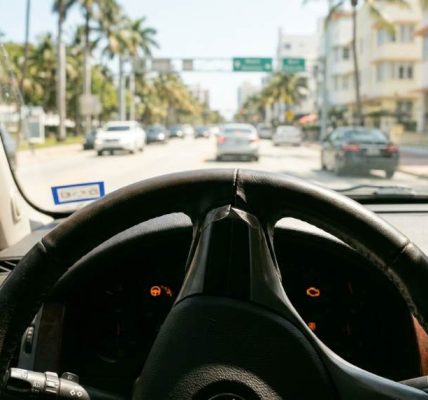 Driver experiencing steering wheel stiffness in a car under Miami heat conditions