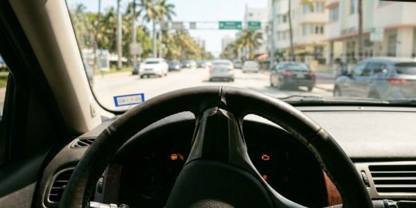 Driver experiencing steering wheel stiffness in a car under Miami heat conditions